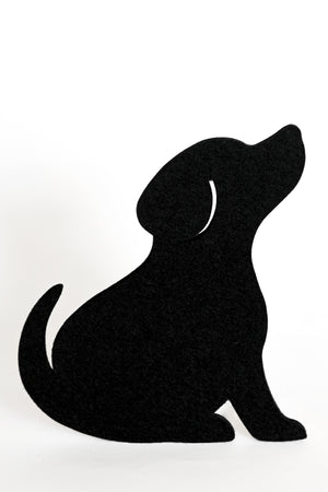 A black felt dog silhouette is a coaster shaped like a sitting dog looking upward, shown on a plain white background.