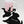 A white ceramic mug with pink horizontal stripes and a black puppy illustration sits on a black felt dog-shaped coaster. Another black felt dog-shaped coaster in the foreground has the words 'love is felt' in white script.