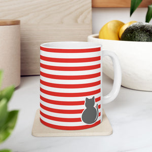 A white ceramic mug with red and white horizontal stripes and a gray cat silhouette, sitting on a beige coaster on a kitchen counter.